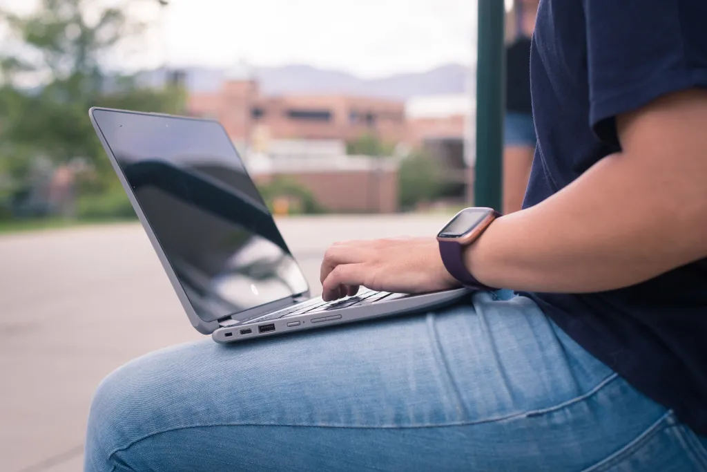 Student with working on a laptop on their lap 