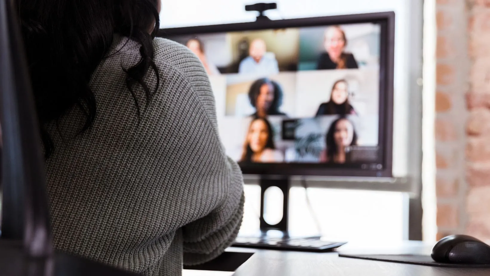Person sitting on a computer participating in a virtual meeting 